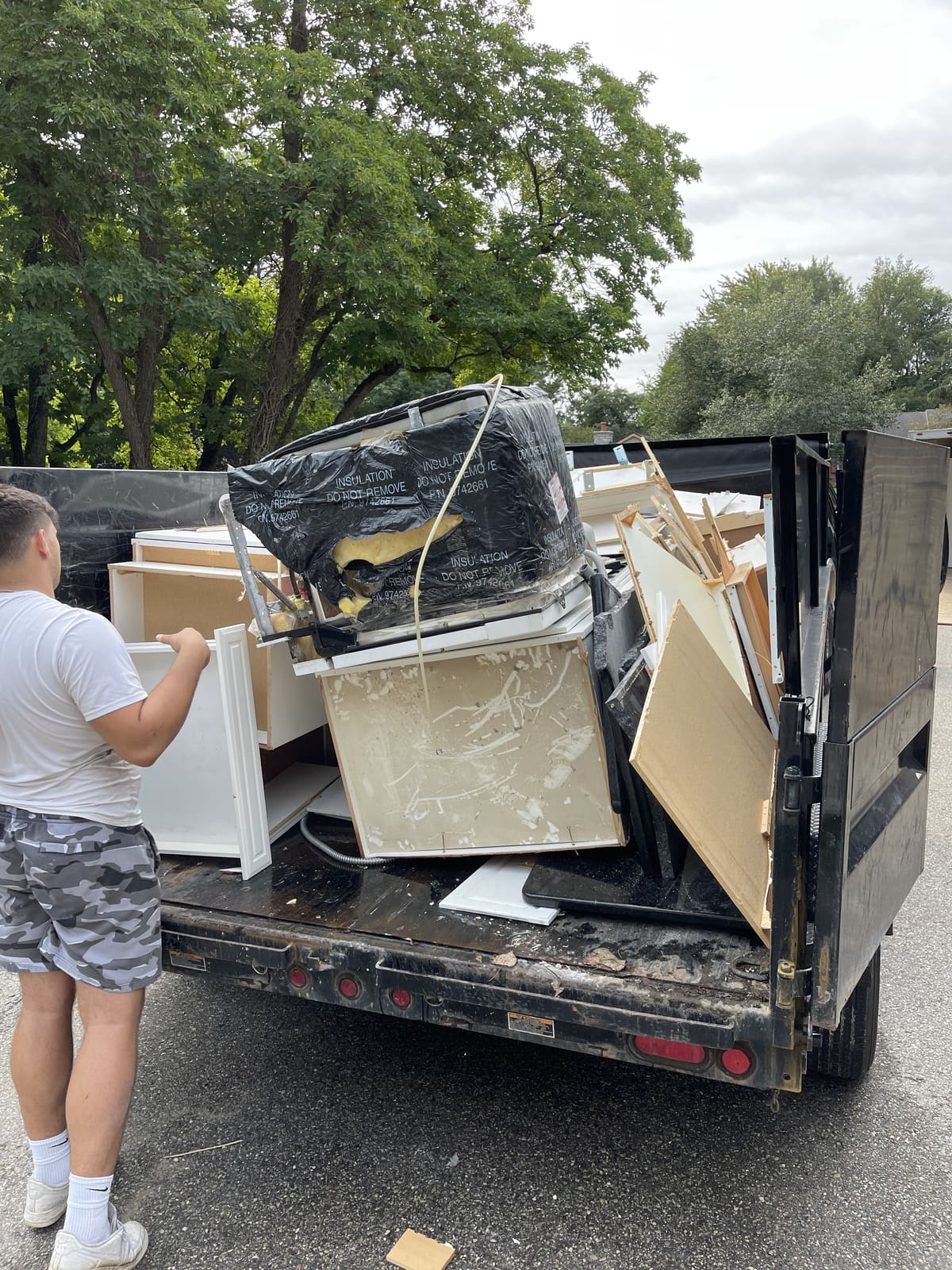 Crew member loading cabinets and appliances into a truck during a cleanout