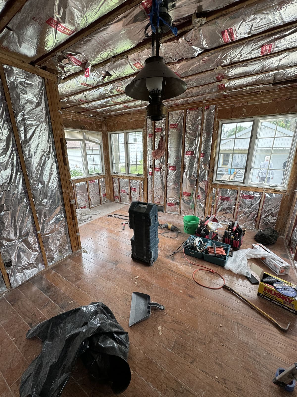 Interior demolition with wall insulation exposed and the flooring removed