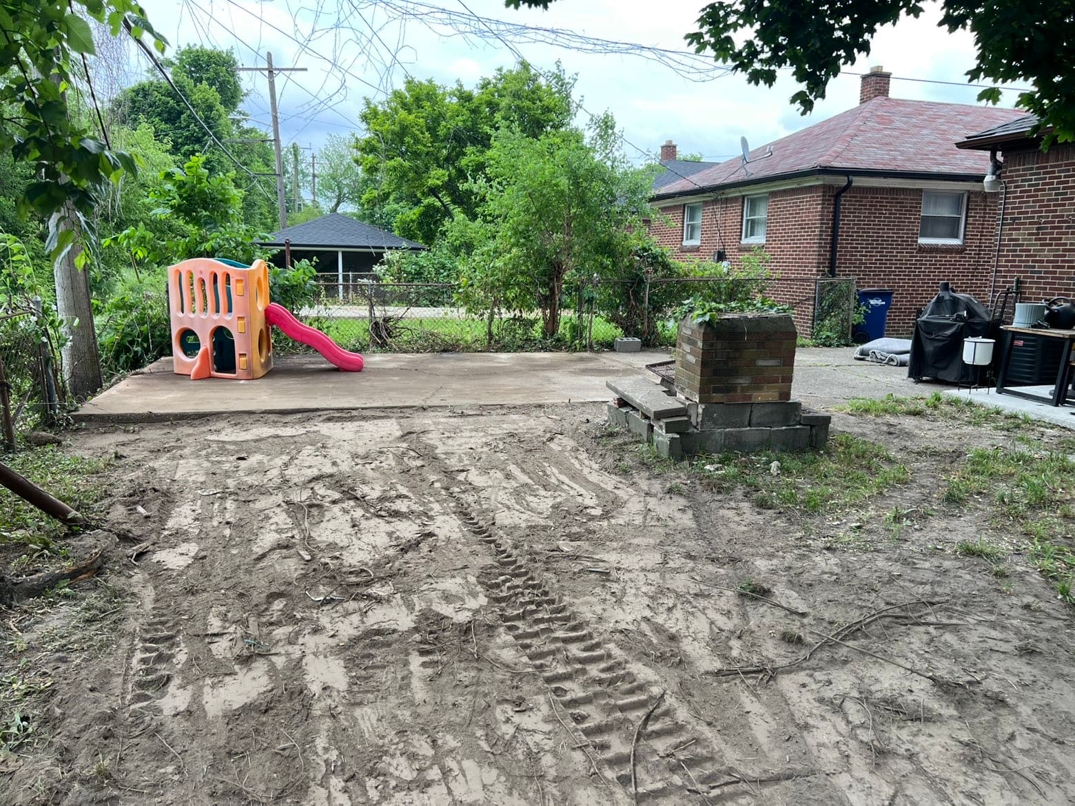 Concrete slab left after a garage demolition beside a brick house
