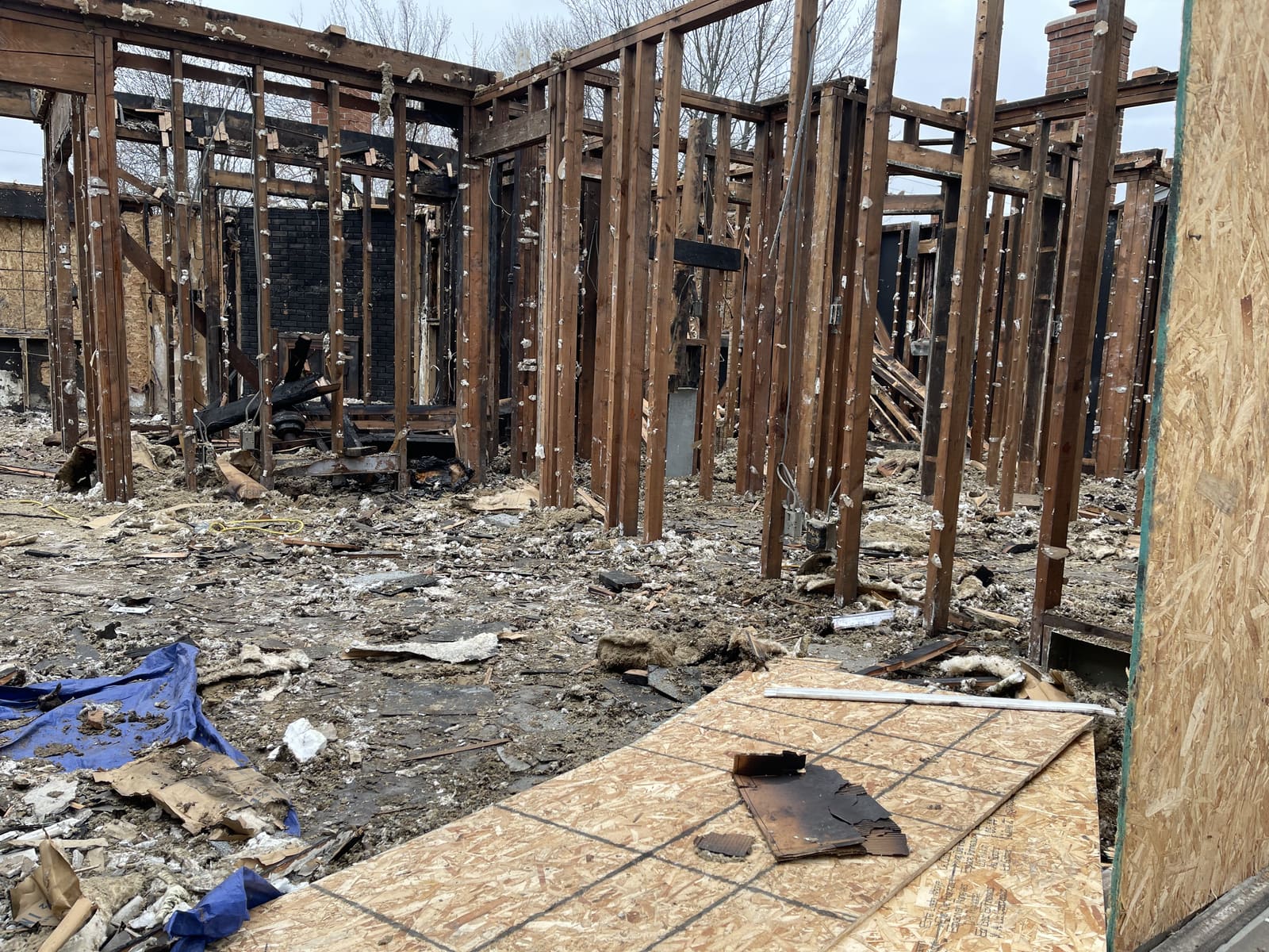 Fire-damaged structure with framing and debris still inside