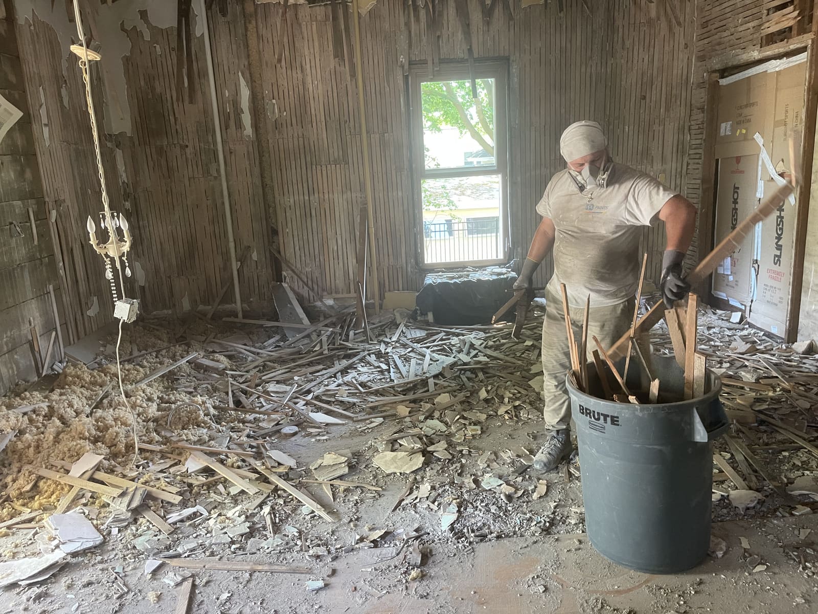 Worker clearing debris from a fire-damaged room
