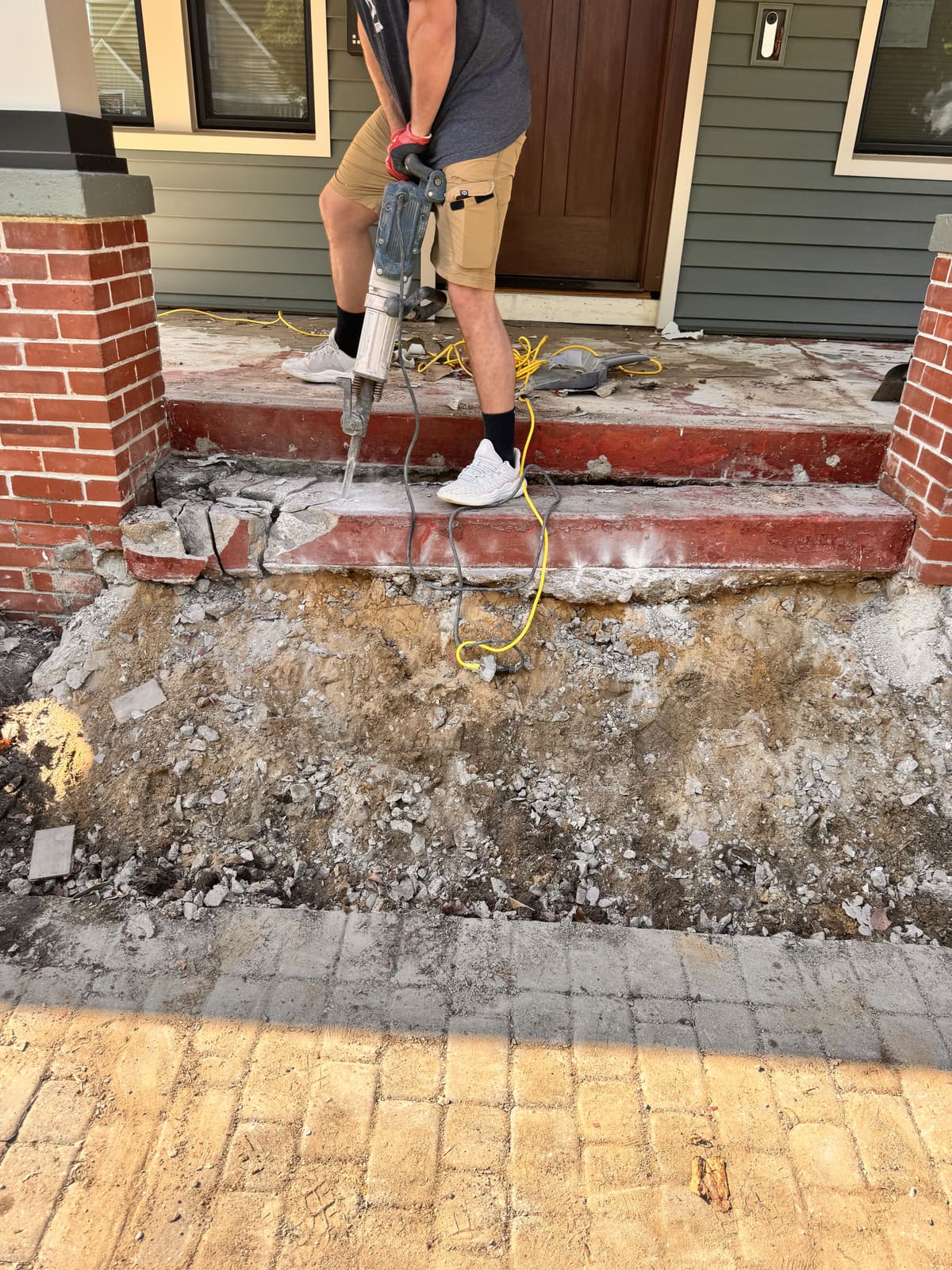 Jackhammering brick front steps during a masonry demolition