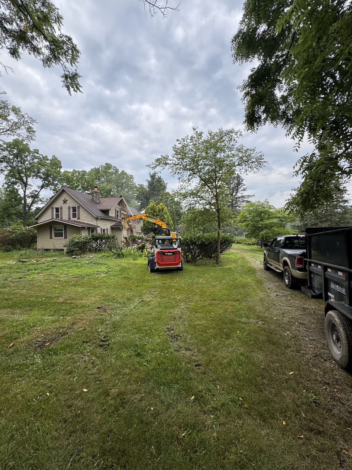 Excavator and skid steer set up for a house demolition