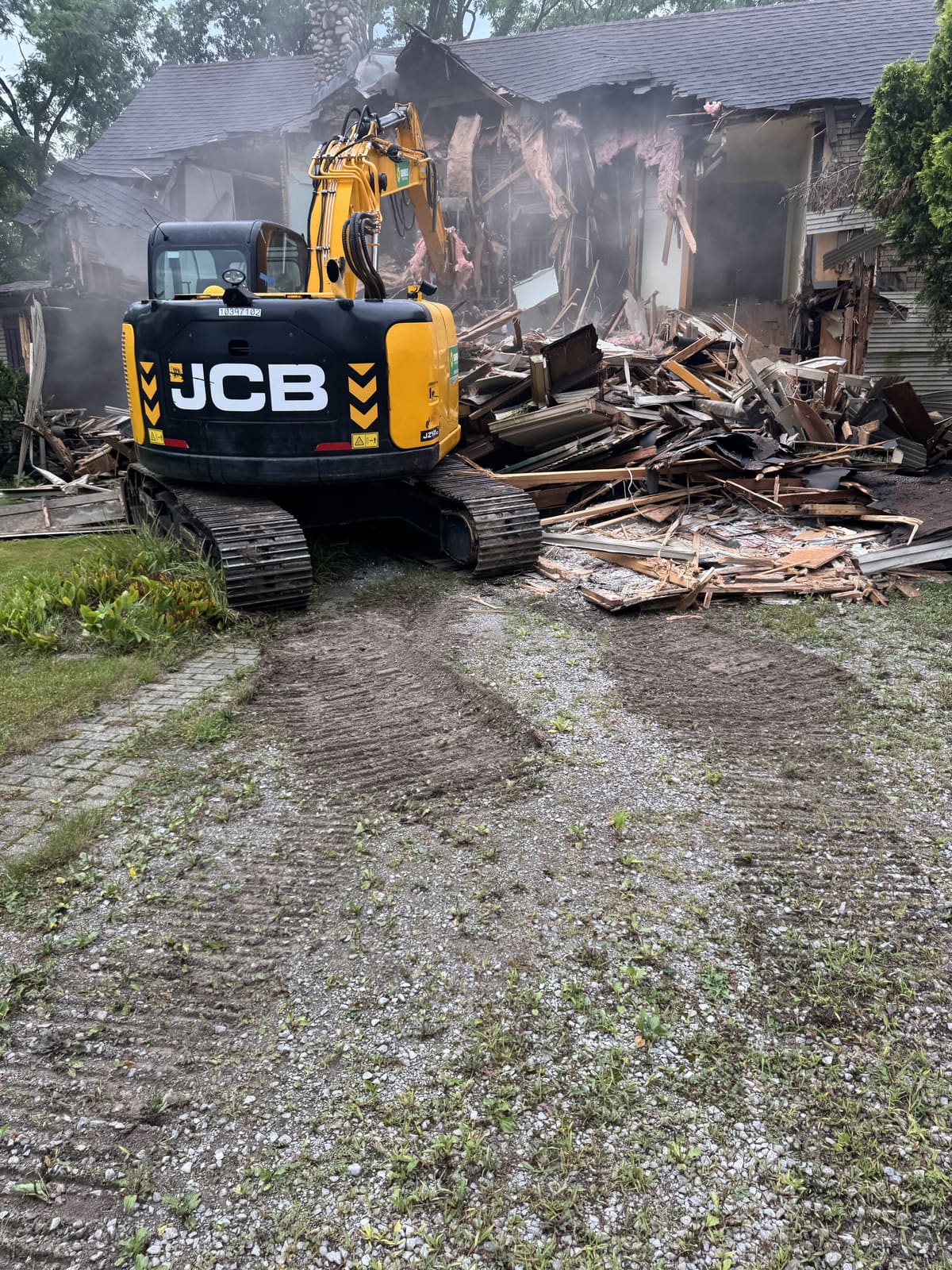 Excavator sitting on a pile of demolition debris