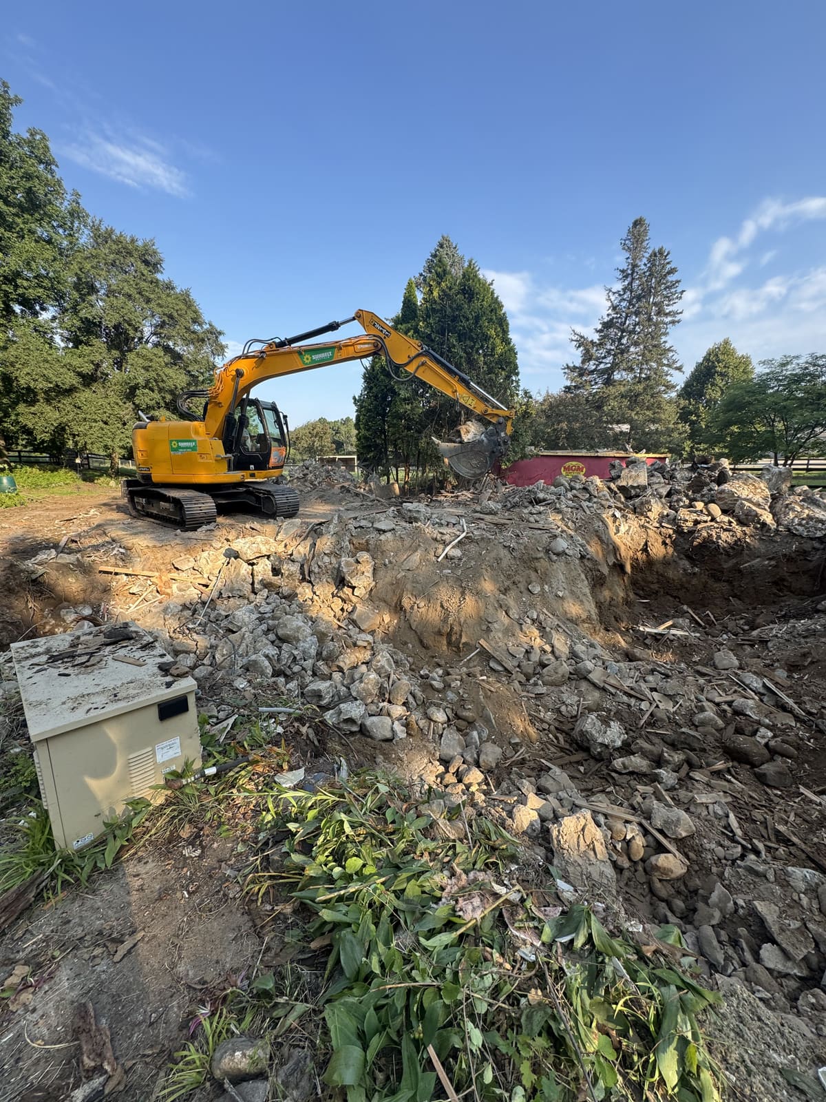 Excavator digging out a foundation after demolition