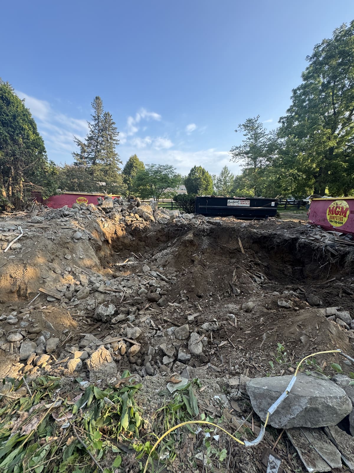 Open excavation with roll-off dumpsters at the edge