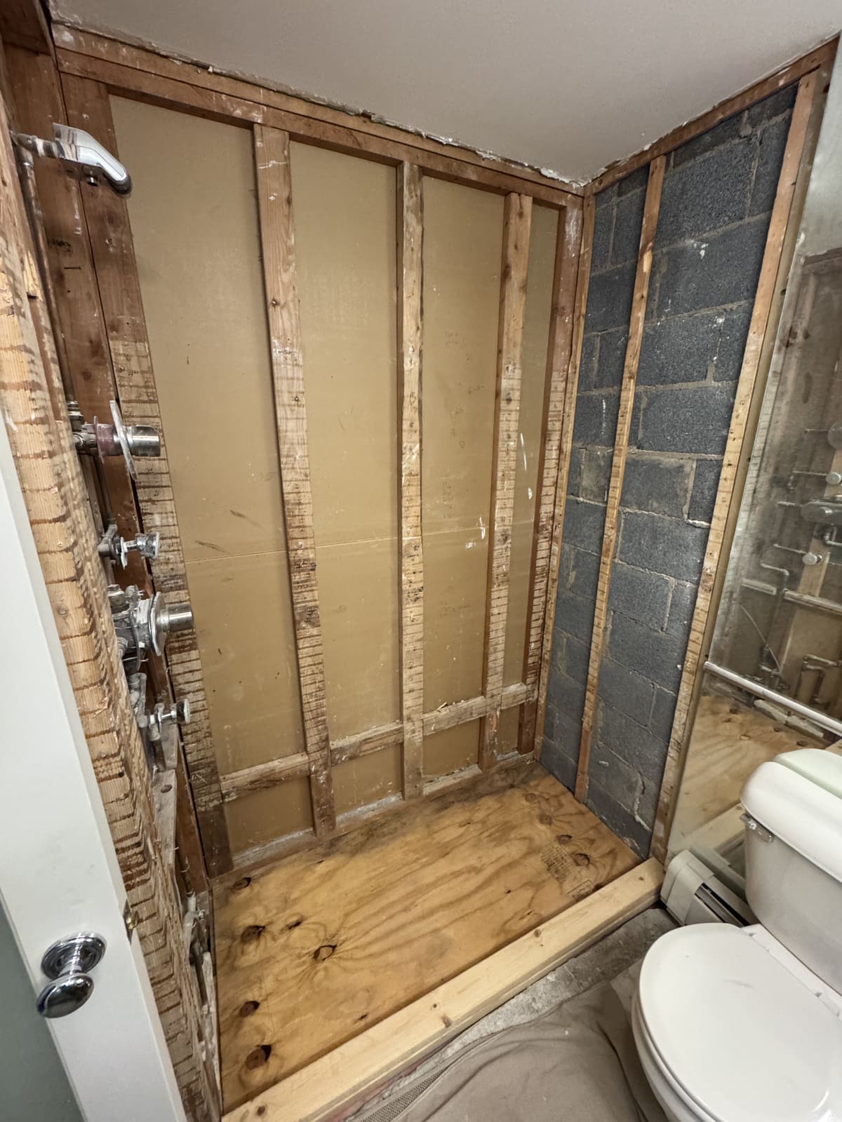 Utility room opened to the studs with plumbing lines still in the wall