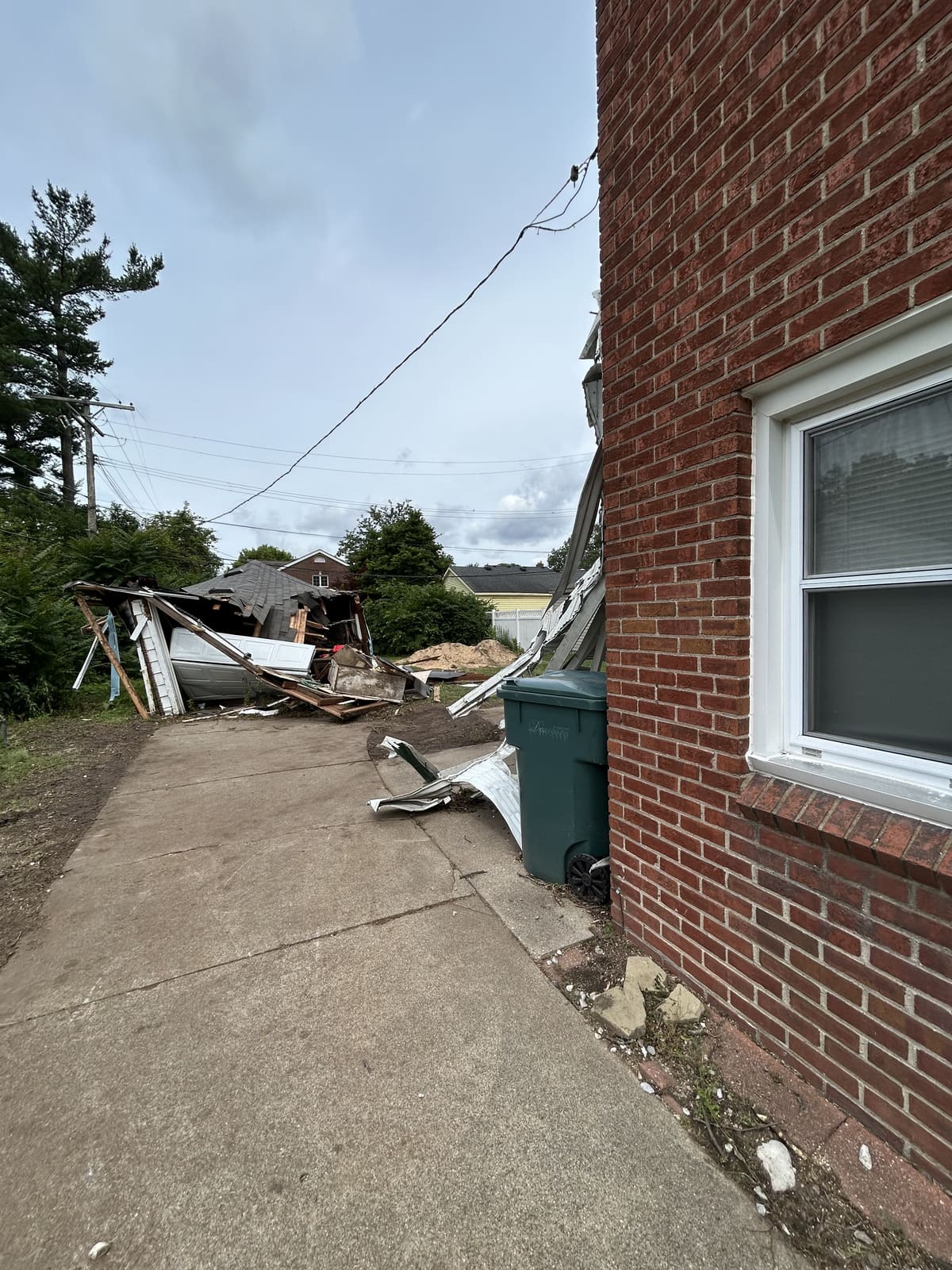 Collapsed addition beside a brick house